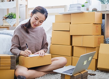 Woman filling out form and preparing packages